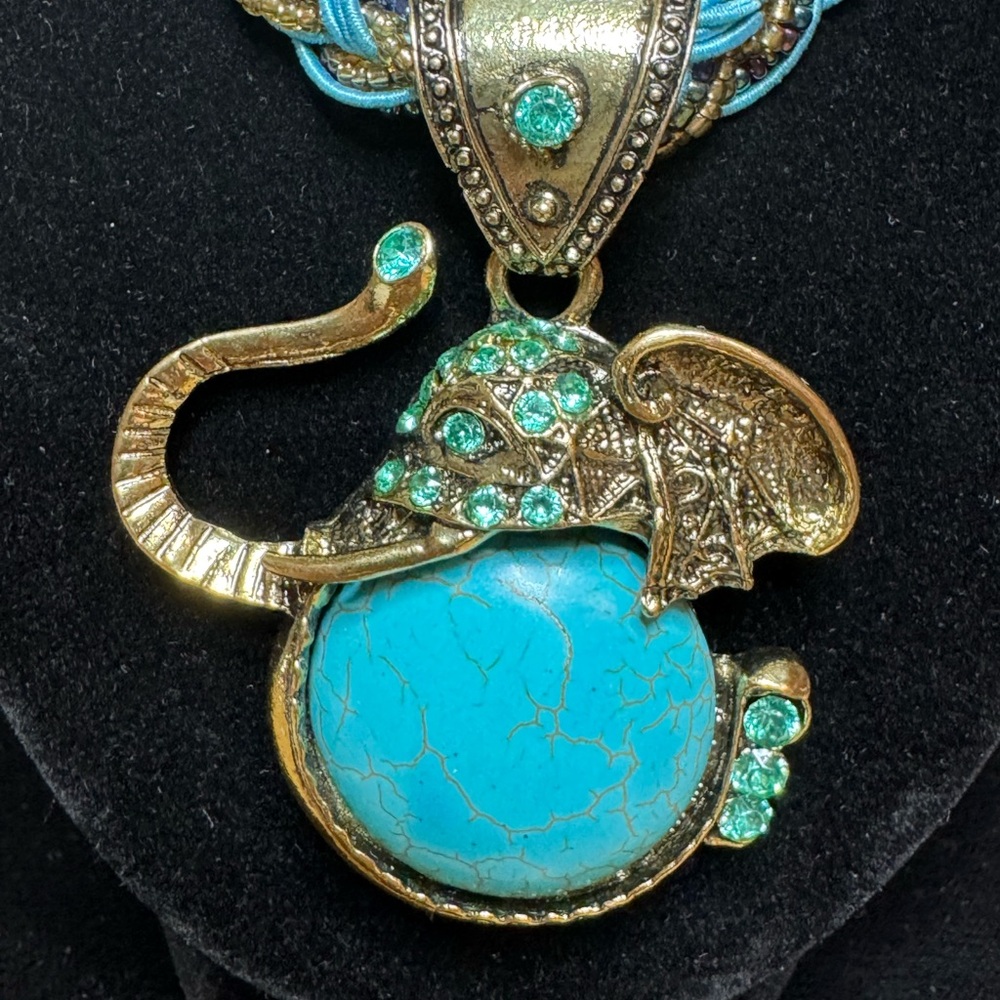 Noradab Fab turquoise on gold tone elephant pendant on braided cord necklace